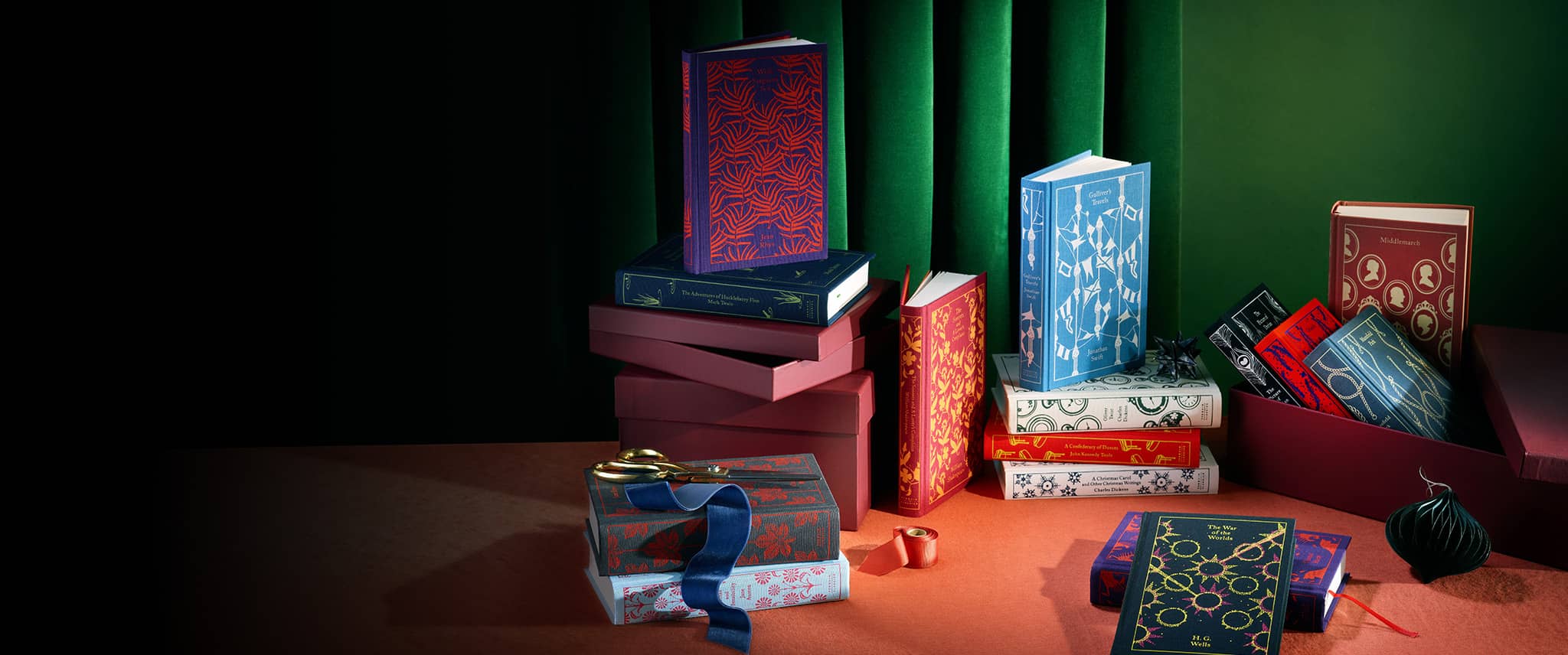 Bestselling clothbound classics on oragne clothed table with a bauble and gift wrapping equipment