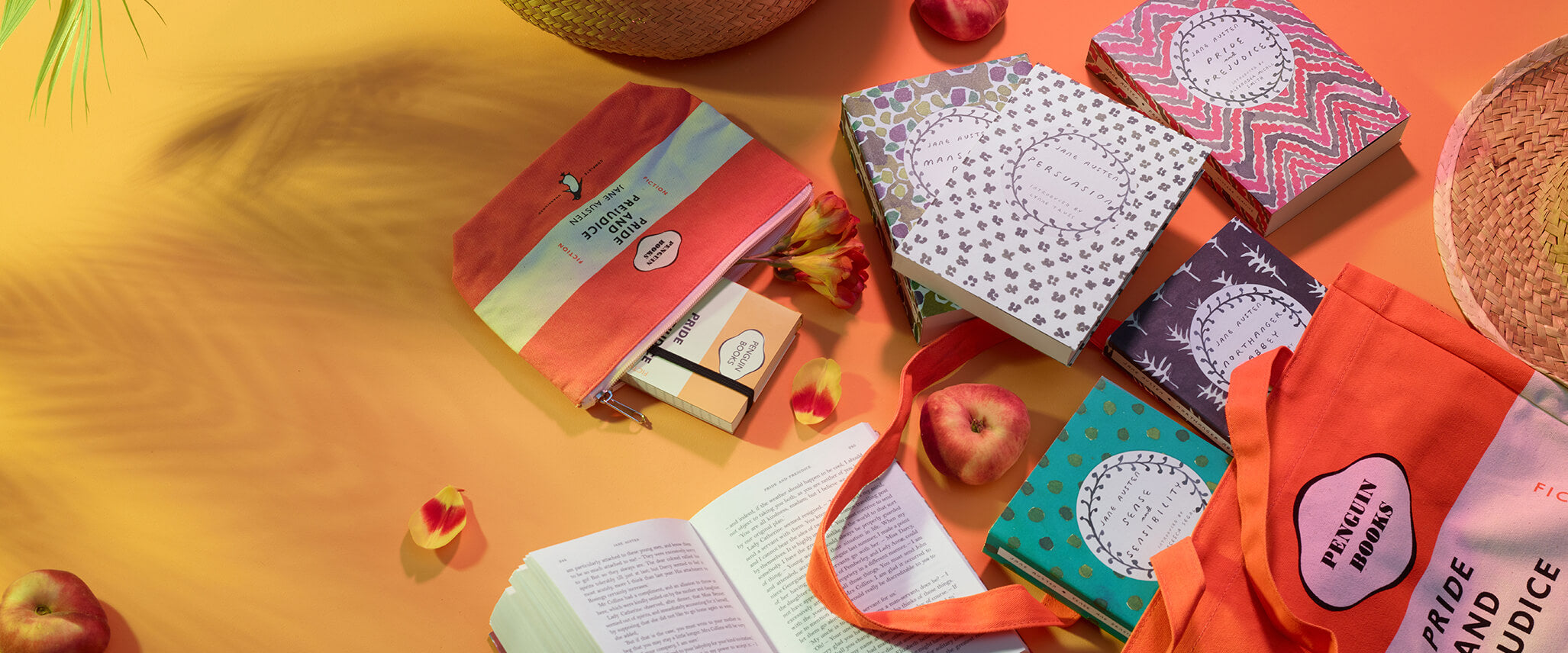 Penguin pencil case, notebook, tote and books on a yellow background