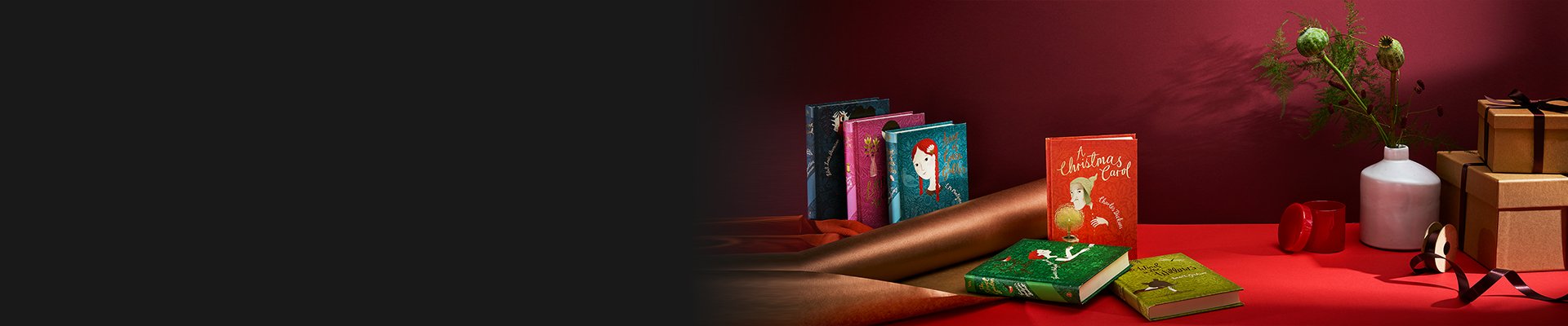 V&A Classic Children's books on a red background with metallic wrapping paper, boxes and a vase